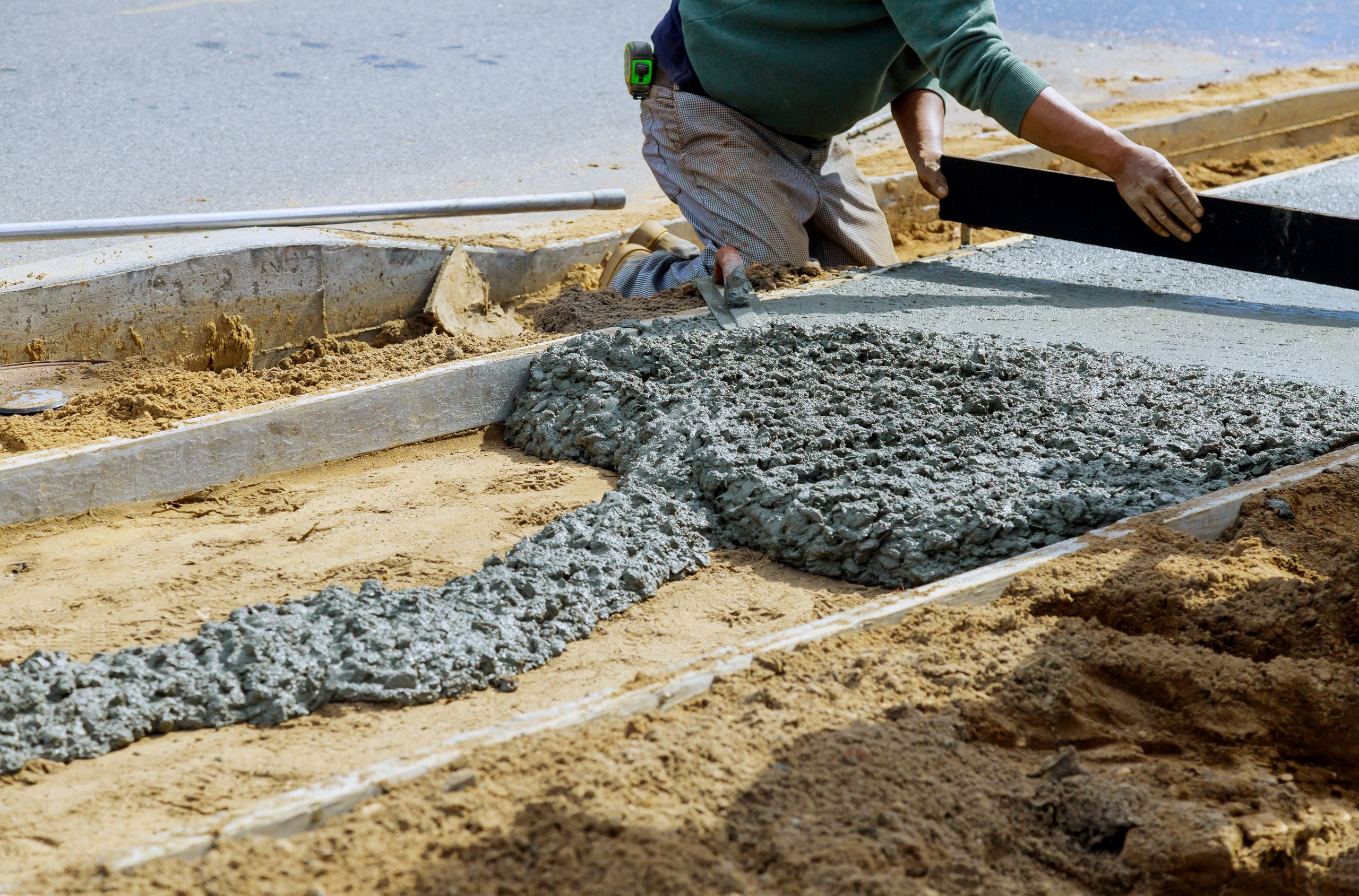 concrete-sidewalk-installation-worker-leveling-wet-cement-concrete-paving