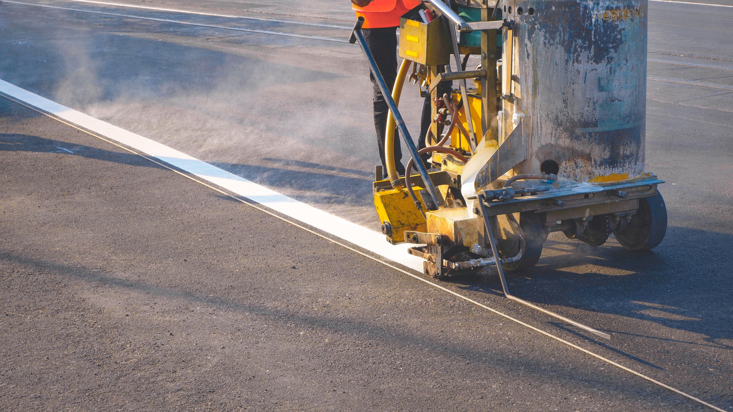 road-striping-machine-applying-white-paint-to-asphalt